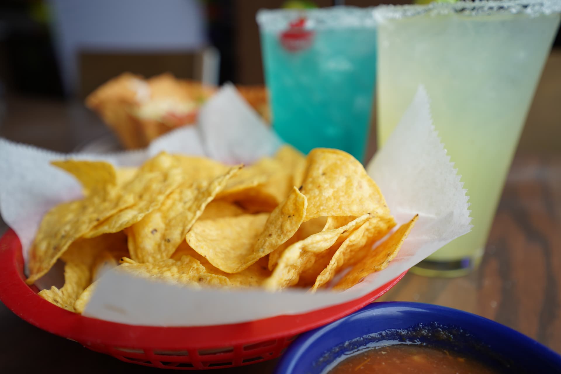 Basket of tortilla chips with salsa and margaritas
