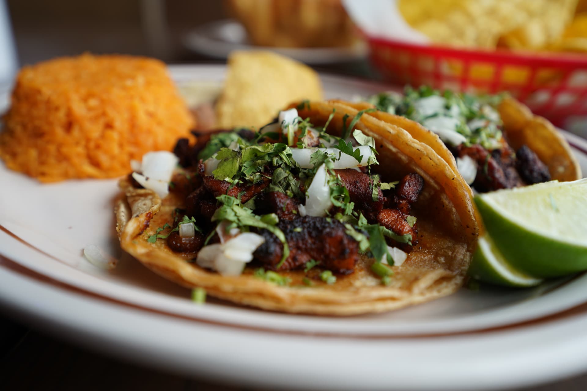 Close-up of carne asada tacos topped with onion and cilantro